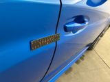 a close up of a blue car with a sticker on it