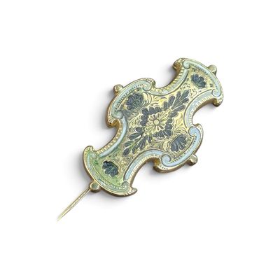 une broche dorée et bleue fixée à un bâtonnet