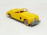 a yellow toy car that is sitting on a white surface
