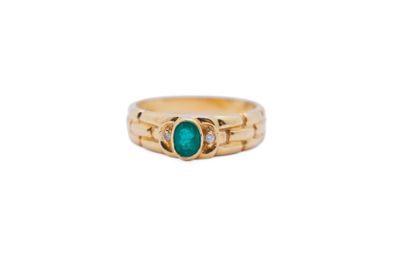 a close up of a gold ring with a green stone