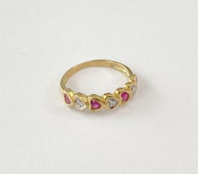 gros plan d'une bague en or avec des pierres roses et blanches