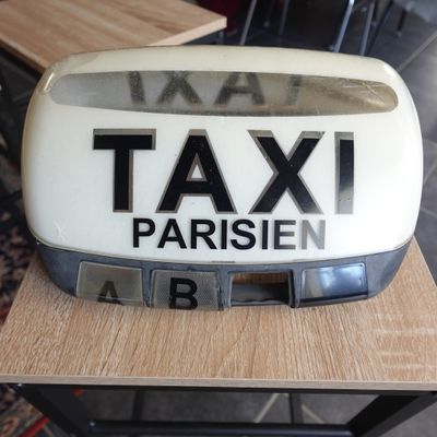 une pancarte « taxi » posée sur une table dans une pièce