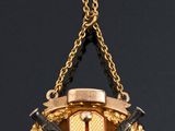 a gold and black clock hanging from a gold chain