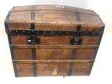 une malle en bois munie de sangles métalliques