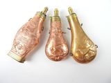 trois bouteilles de vin anciennes sont alignées sur une surface blanche
