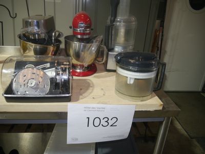 une table sur laquelle se trouvent un mixeur, un batteur, un blender et d'autres ustensiles de cuisine