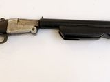 un gros plan d'un pistolet accroché au mur, sur fond blanc
