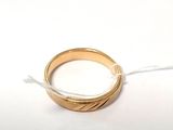 une bague en or suspendue à un fil sur une surface blanche