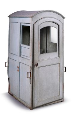 une vieille toilette extérieure munie d'une porte et d'une fenêtre