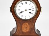 a small wooden clock with roman numerals on the face