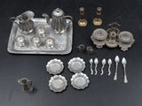 a silver tray with silverware and silver spoons on a table