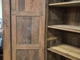 a large wooden cabinet with shelves in a room