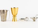two cups and a pitcher sitting next to each other on a table