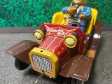 une figurine représentant un homme au volant d'une petite voiture