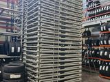 a large stack of tires sitting on top of a pallet in a warehouse