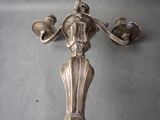 a silver cross on a table with two bells
