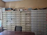 un bureau sur lequel est posé un ordinateur portable, devant un mur de classeurs