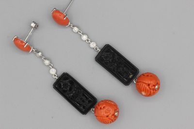 une paire de boucles d'oreilles noires et orange ornées de perles sculptées
