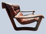 a brown leather chair with a wooden frame on a blue background