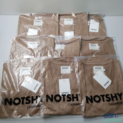six brown t - shirts are wrapped in plastic bags on a table