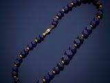 a close up of a blue beaded necklace on a dark background