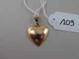 un pendentif en or en forme de cœur orné d'un diamant