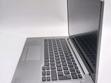 a silver laptop with a black keyboard on a white surface