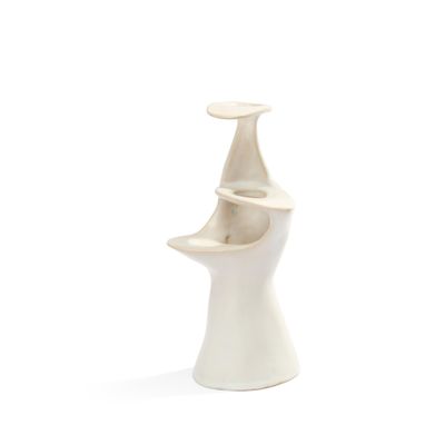 un vase blanc muni d'une anse incurvée, posé sur une surface blanche