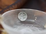 a close up of a glass bowl with a coin in it