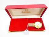 une image représentant une montre en or dans un coffret rouge posé sur une surface blanche