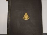 an old book with a gold emblem on it sitting on a table
