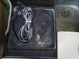a black box with a charger on top of it next to a sink