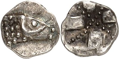 a silver coin with an eye on the front and a face on the back