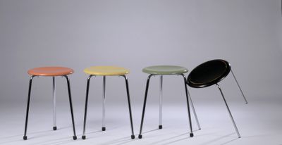 trois tabourets de couleurs différentes, placés les uns à côté des autres sur une surface blanche