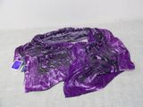 purple and black scarf on a bed with a tag on it