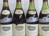 six bouteilles de vin sont alignées sur une étagère