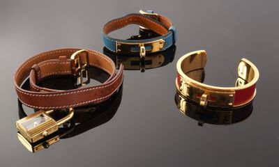 three different colored bracelets with a lock on a black surface