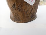 a brown vase with a sticker on it sitting on a table