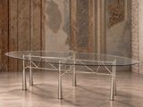 une table en verre avec des pieds en métal dans une pièce