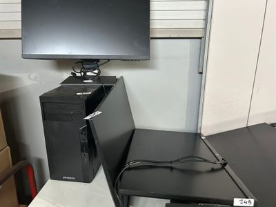 un ordinateur de bureau posé sur un bureau, à côté d'un écran