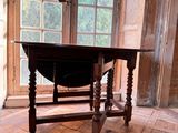 a wooden table sitting in front of a window in a room