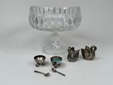 a glass bowl with spoons, spoons and spoon rest on a table