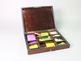 a wooden box filled with assorted items on a white surface