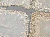 several pieces of white lace on a gray surface with a gray background