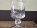a clear glass vase sitting on a wooden table