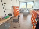 une pièce avec une table, des chaises et des étagères