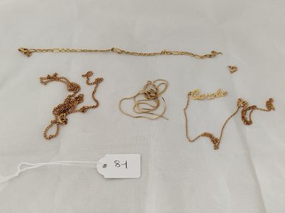 a group of gold necklaces and bracelets on a white surface