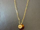 un collier composé d'un disque en or monté sur une chaîne en or