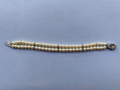 un bracelet de perles blanches avec un fermoir en argent