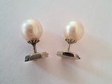 deux paires de boucles d'oreilles en perles et en or posées sur un fond blanc